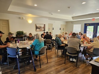 Older adults eating lunch provided by fire fighters